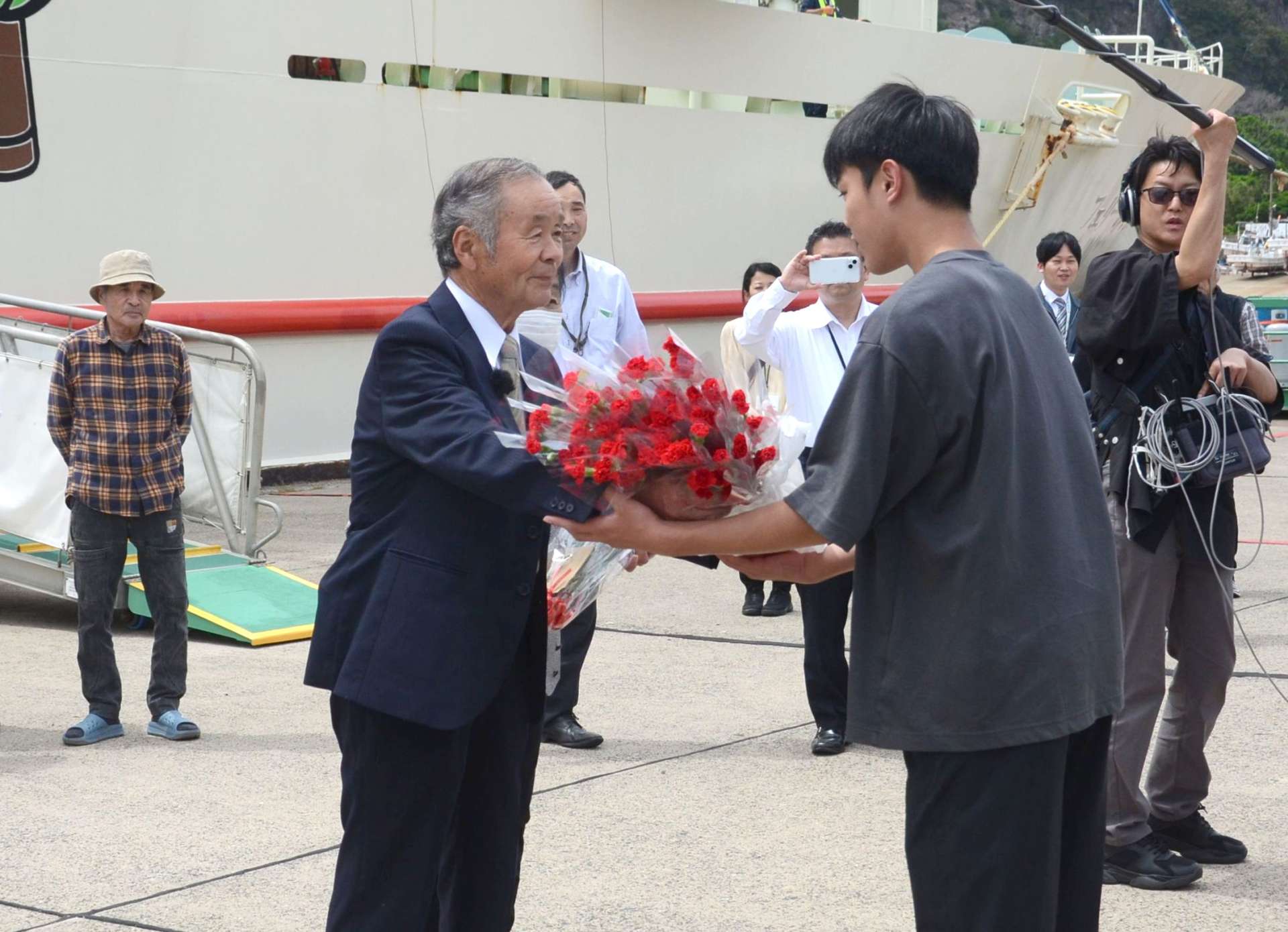 カーネーションを子どもに手渡す田知行義久さん＝１０日、三島村硫黄島