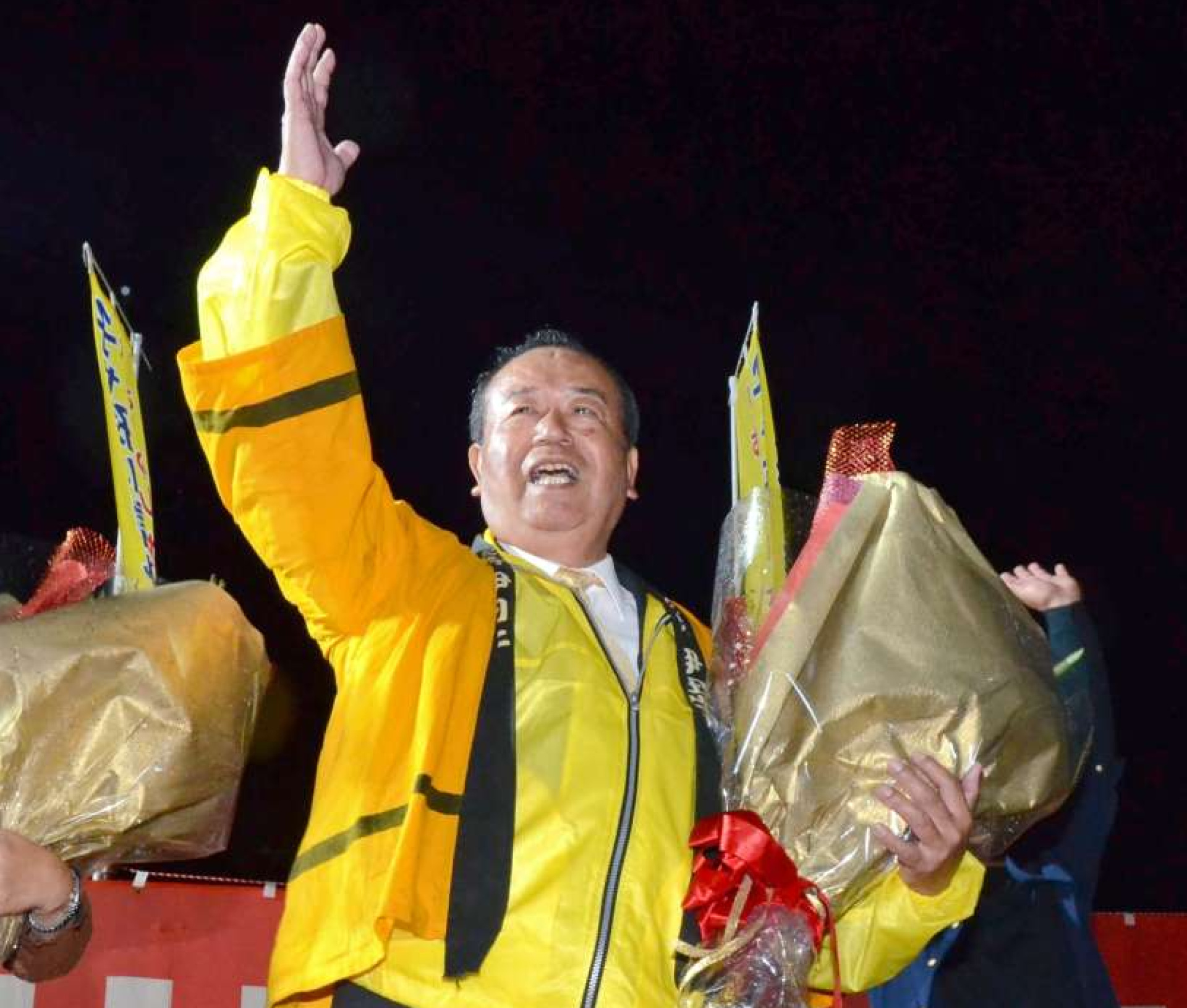 万歳三唱をして初当選を喜ぶ伊田正則さん（中央）＝１１日午後９時５０分ごろ、伊仙町伊仙