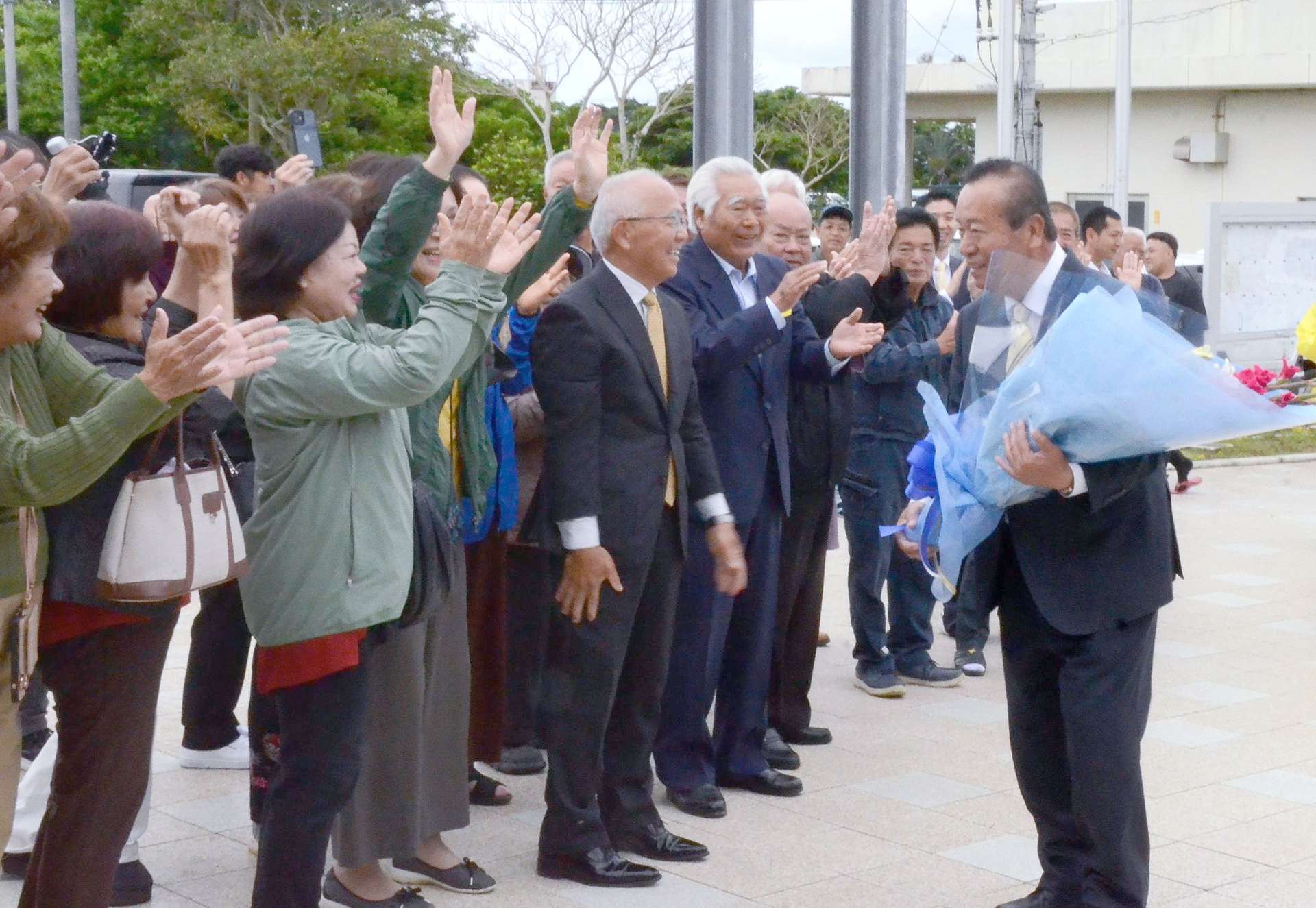 町民や職員に迎えられ初登庁する伊田正則氏＝１２日、伊仙町役場