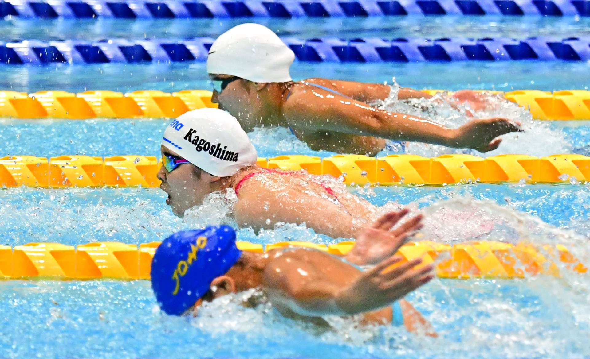 〈資料写真＝前年大会より〉接戦／中盤まで横一線。的確に水を捉えて記録を狙う＝２０２４年５月３１日、鴨池公園プール（競泳女子１００メートルバタフライ決勝）