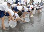 ヒラメの稚魚を放流する児童ら＝指宿市の指宿港海岸