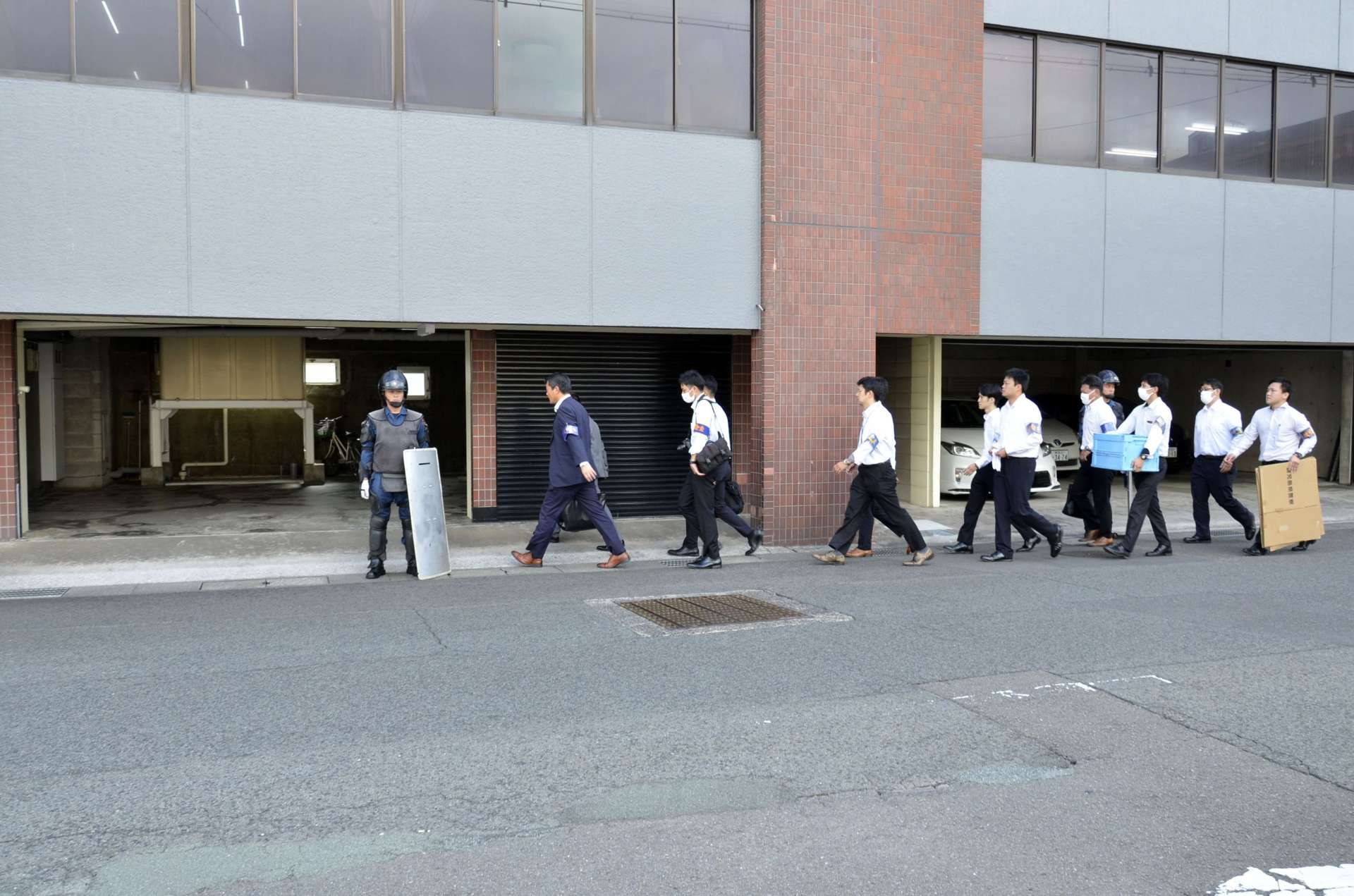 小桜一家本部事務所に家宅捜索に入る県警の捜査員＝１９日午前１０時ごろ、鹿児島市甲突町