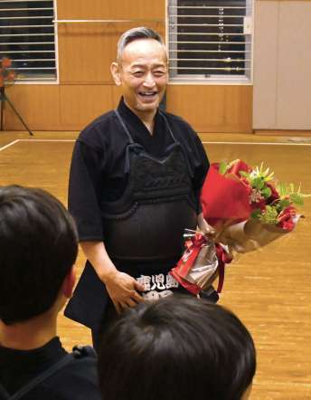 剣道８段に昇段し、教え子から祝福される野間亮二さん＝鹿児島中央警察署