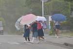 傘を差して通学する小学生＝１６日、鹿児島市吉野町