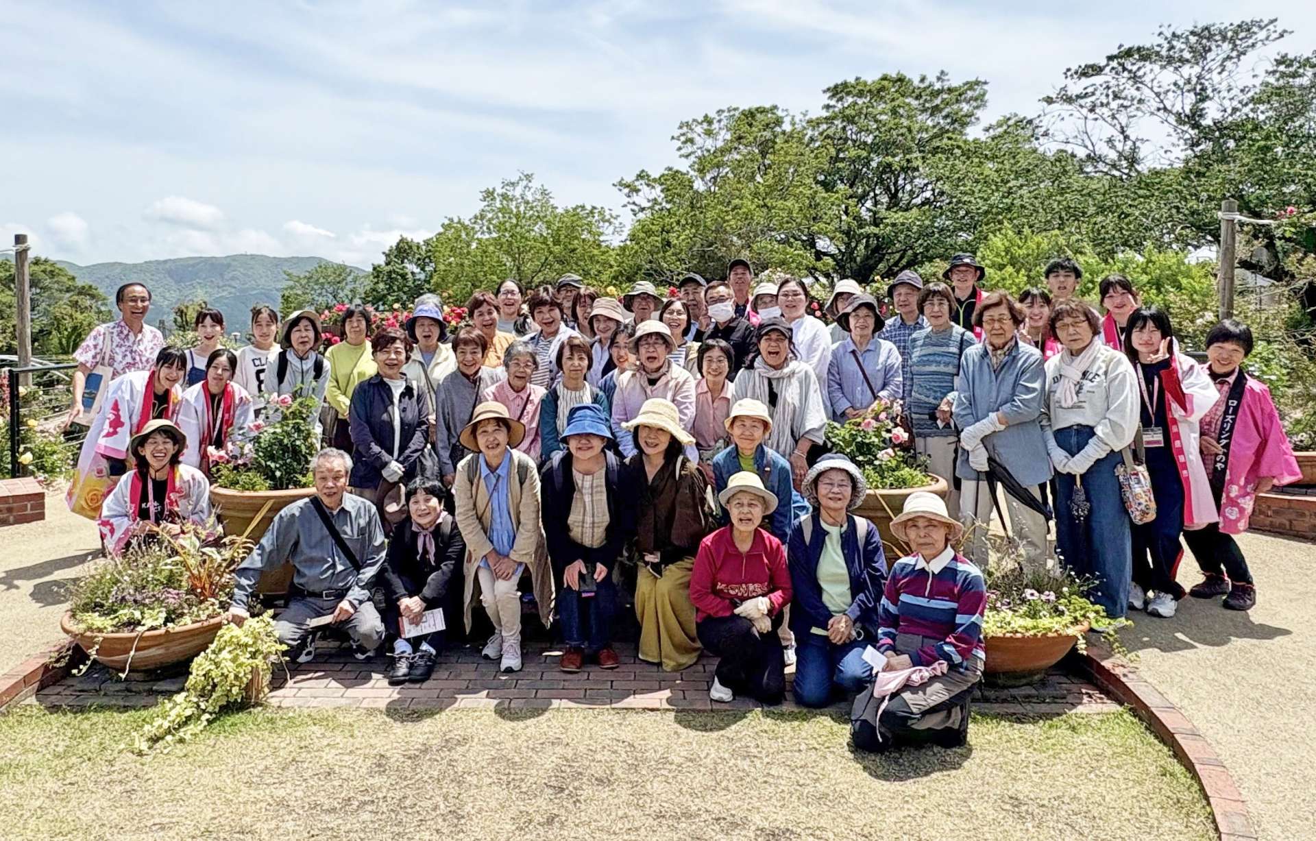 かのやばら園で記念撮影するバスツアー参加者＝鹿屋市浜田町