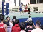 チームメートが見守る中、熱戦を繰り広げるボクシング競技の選手＝１６日、鹿児島市の県補助体育館
