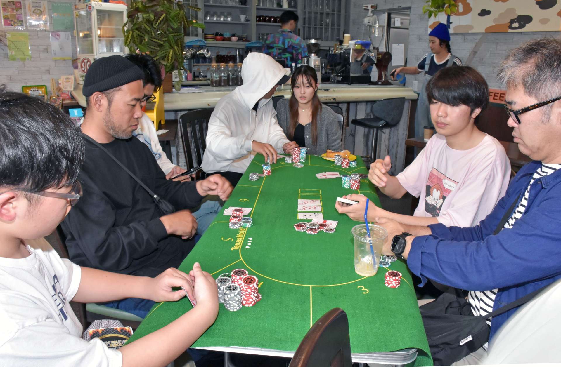 真剣勝負を展開する「阿久根でオールイン」参加者ら＝阿久根市新町のジャンクサーフコーヒー