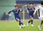 中盤でボールを運ぶ鹿児島Ｕの田中＝鹿児島市の白波スタジアム