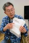 「闇をあばいてください。」と書かれた文書を手にするフリージャーナリストの小笠原淳さん＝４月２４日、札幌市