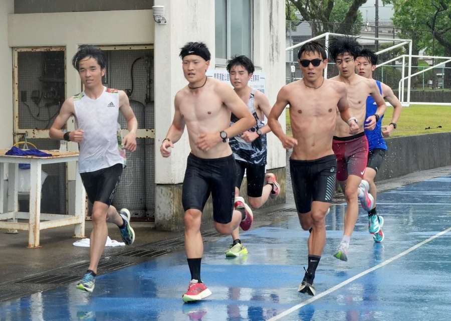 雨の中インターバル走をする選手ら＝１７日、鹿屋市の鹿屋運動公園