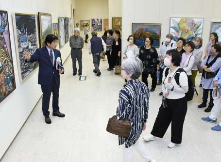 作品解説に耳を傾ける来場者＝１７日、鹿児島市立美術館