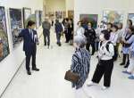 作品解説に耳を傾ける来場者＝１７日、鹿児島市立美術館