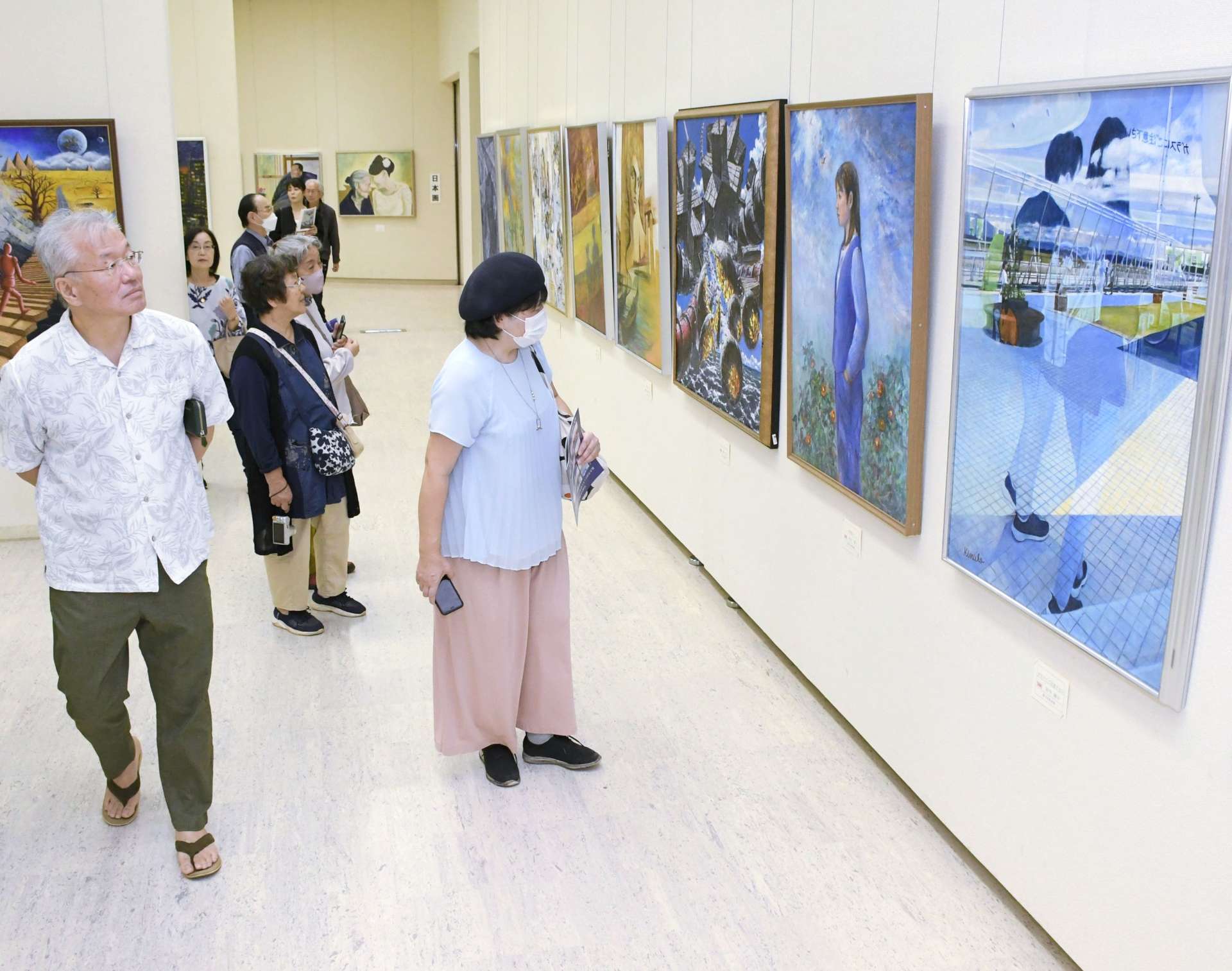 幅広い表現の作品に見入る来場者＝１７日、鹿児島市立美術館