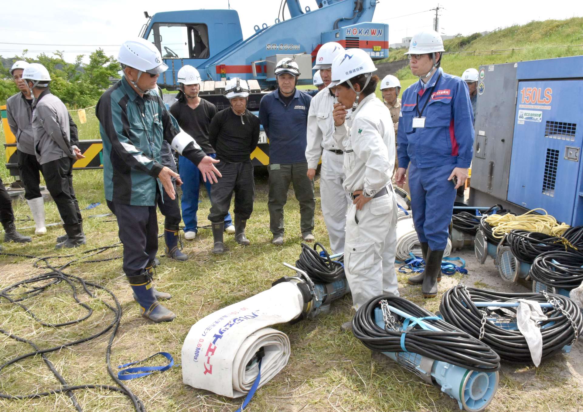 ポンプの組み立て方法を確認する建設業者ら＝肝付町新富