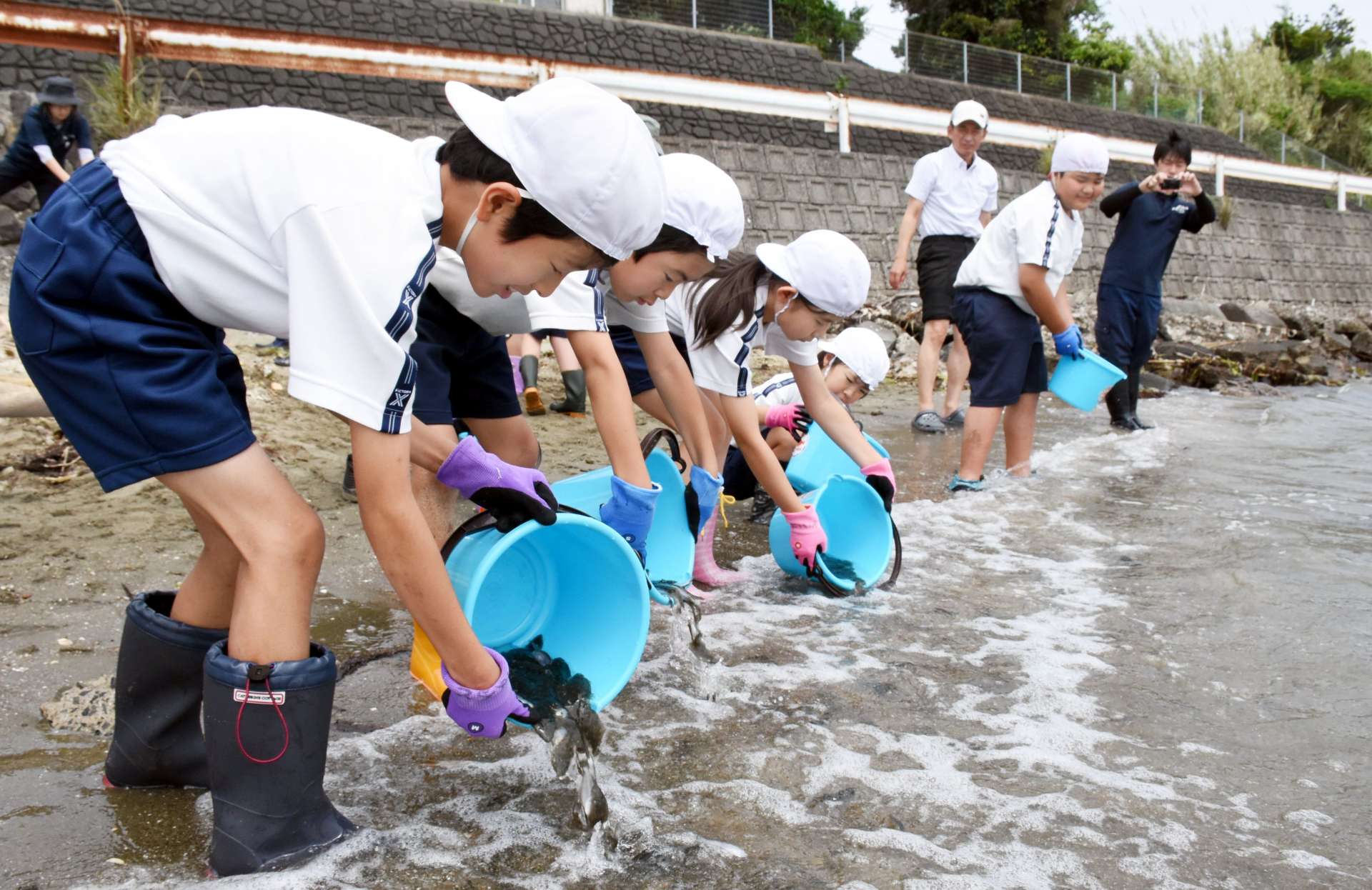 ヒラメの稚魚を放流する児童＝出水市荘