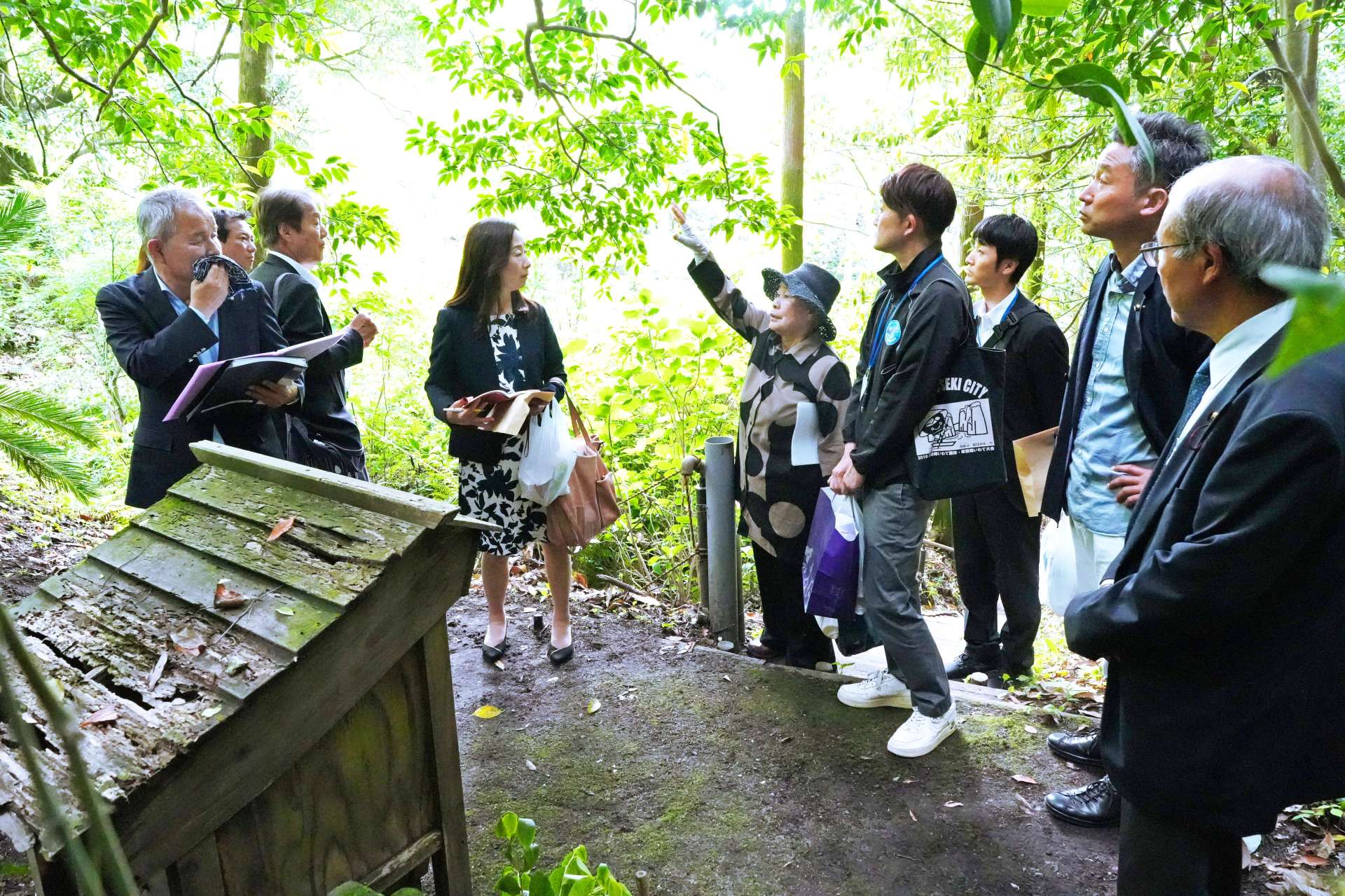 垂水史談会員の説明を聞きながら、宇喜多秀家の潜居跡を視察する岡山市議ら＝垂水市牛根麓