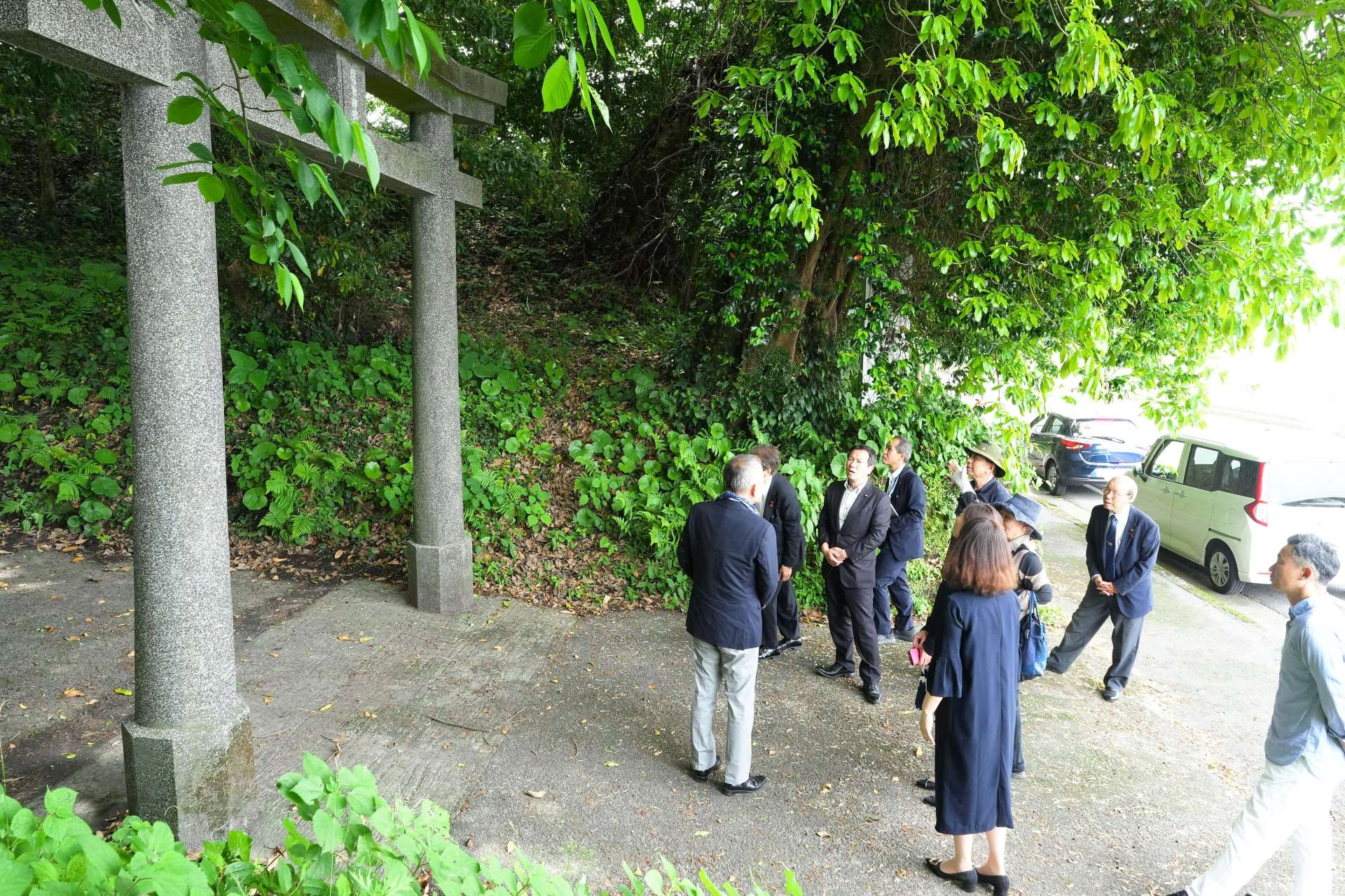 〈別カット〉垂水史談会員の説明を聞きながら宇喜多秀家が参拝したとされる居世神社を視察する岡山市議ら＝垂水市牛根麓