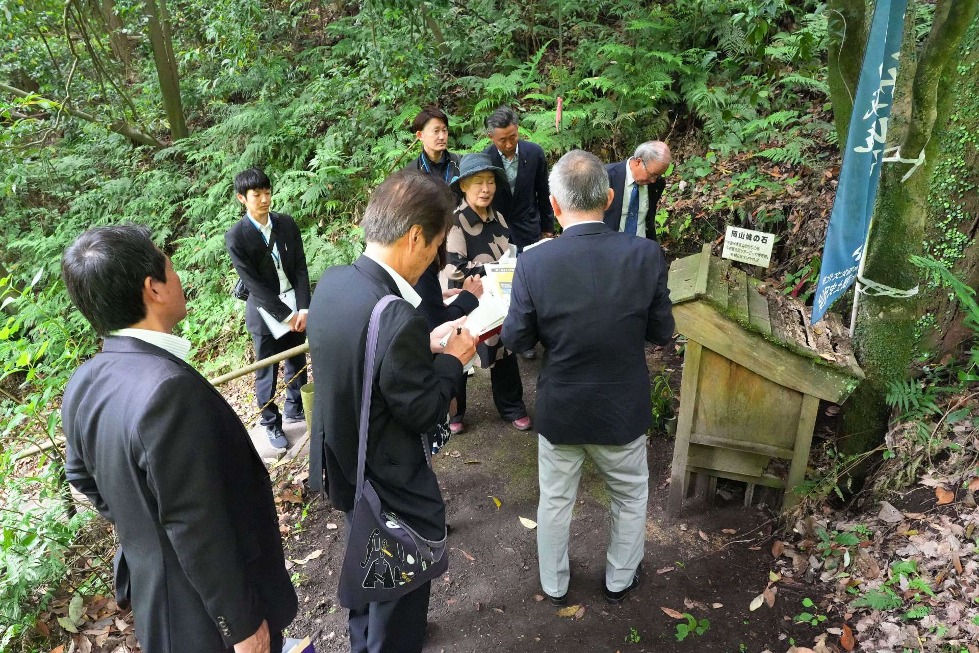 垂水史談会員の説明を聞きながら宇喜多秀家の潜居跡を視察する岡山市議ら＝１５日、垂水市牛根麓