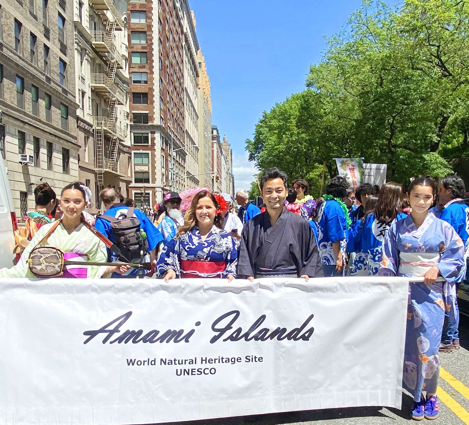「Ａｍａｍｉ　ｉｓｌａｎｄｓ」と書かれた横断幕を掲げる参加者＝米ニューヨーク（ＮＹ奄美会提供）