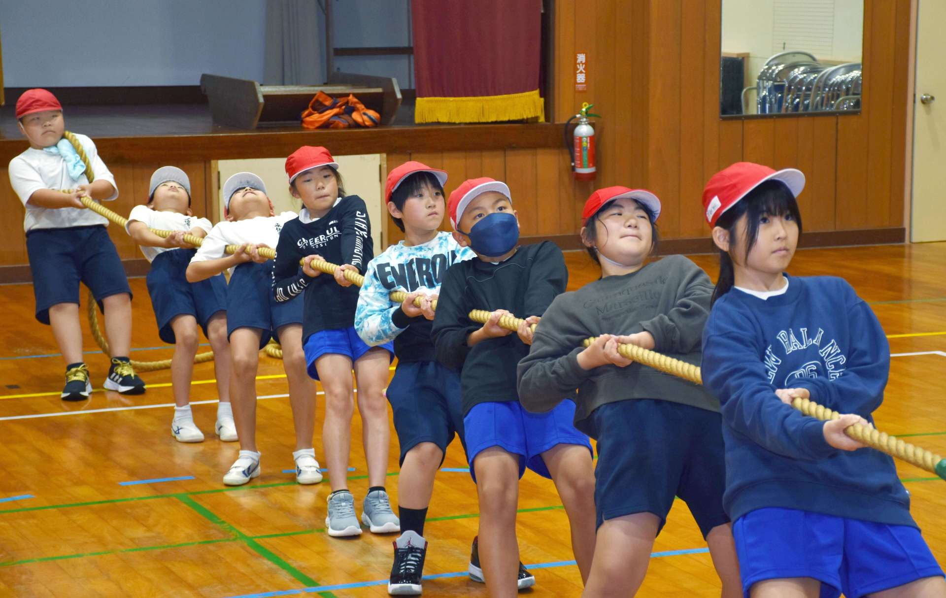 力を合わせて綱を引く平佐東、峰山両小学校の児童＝薩摩川内市の平佐東小学校