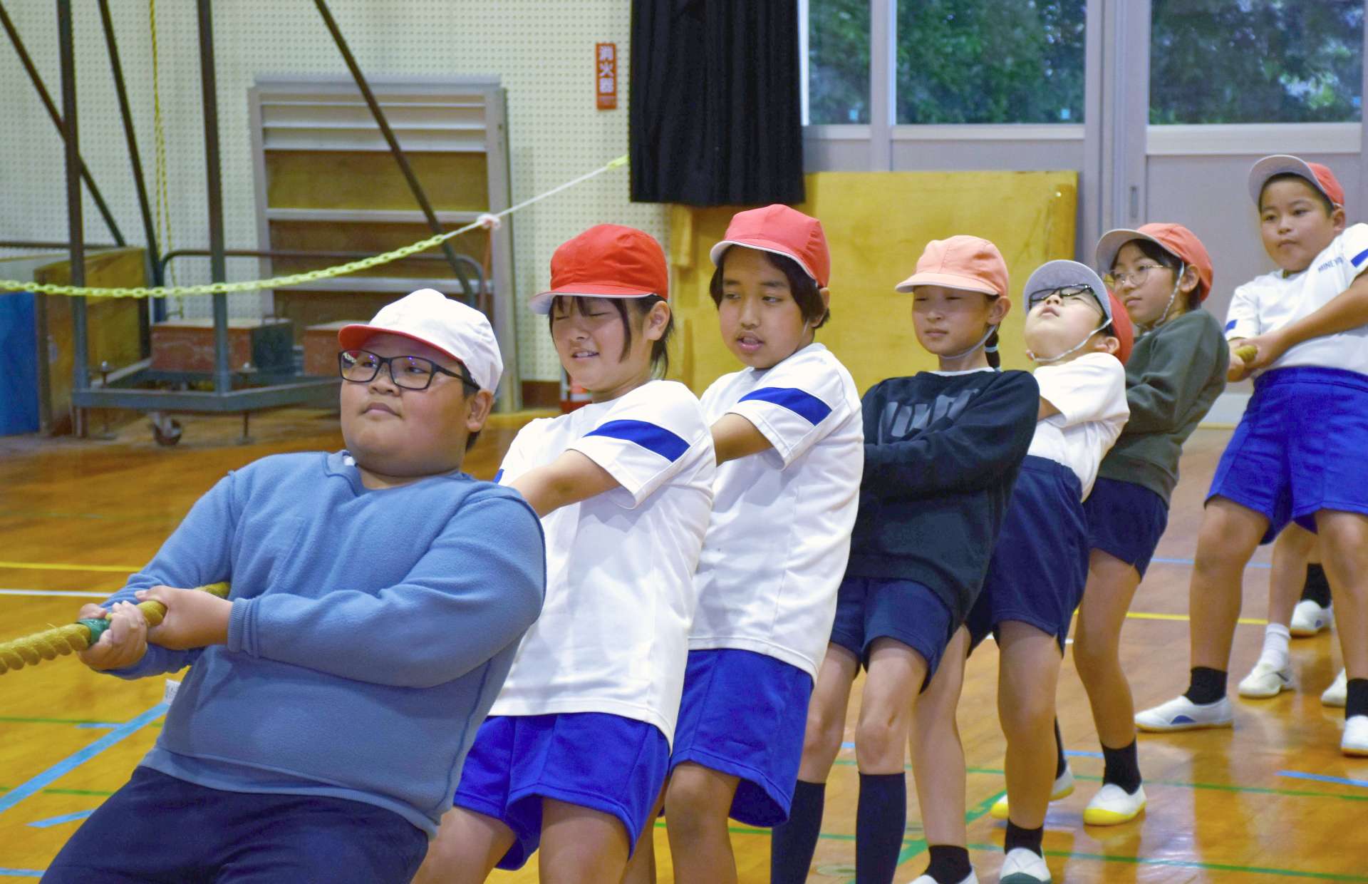 力を合わせて綱を引く平佐東、峰山両小学校の児童＝薩摩川内市の平佐東小学校