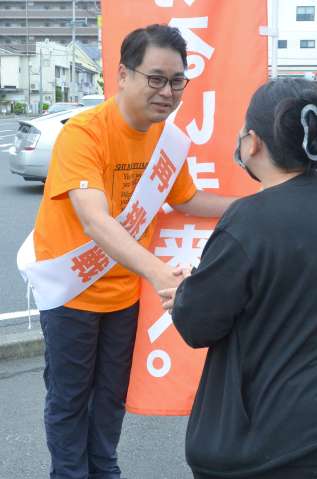 「再挑戦」と記したタスキをかけ、朝のつじ立ちをする保岡宏武氏＝鹿児島市谷山中央１丁目