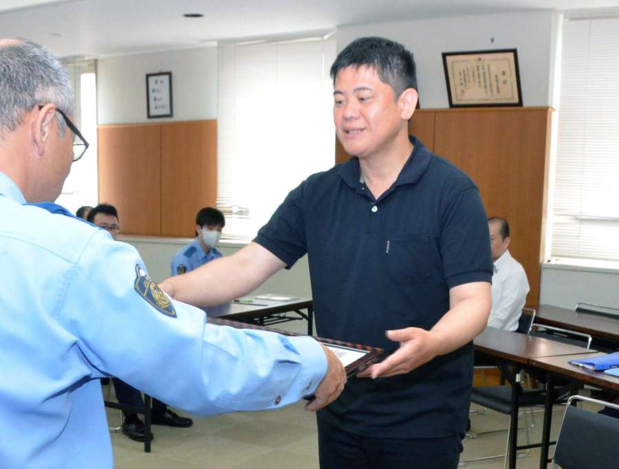 鹿児島中央署の上別府高宏署長から感謝状を受ける鍬崎誠二さん＝２１日、鹿児島市の鹿児島中央署