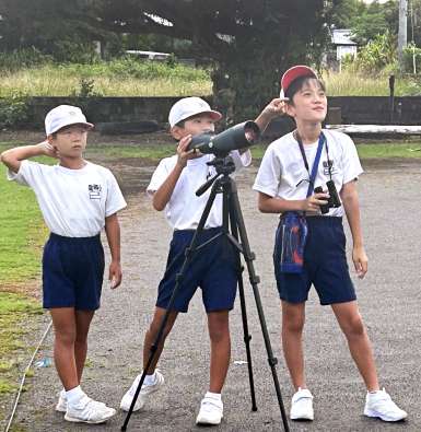 奄美大島に渡ってきたサシバを観察する児童＝２０２４年１０月、龍郷小（同校提供）