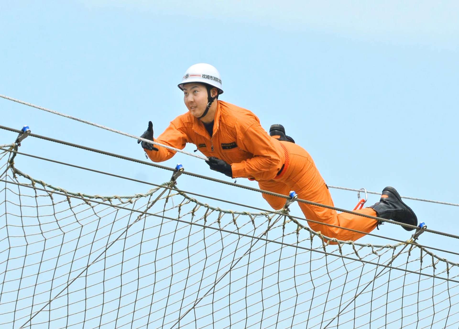 ロープブリッジ渡過に挑む出場者＝２３日、日置市東市来の県消防学校