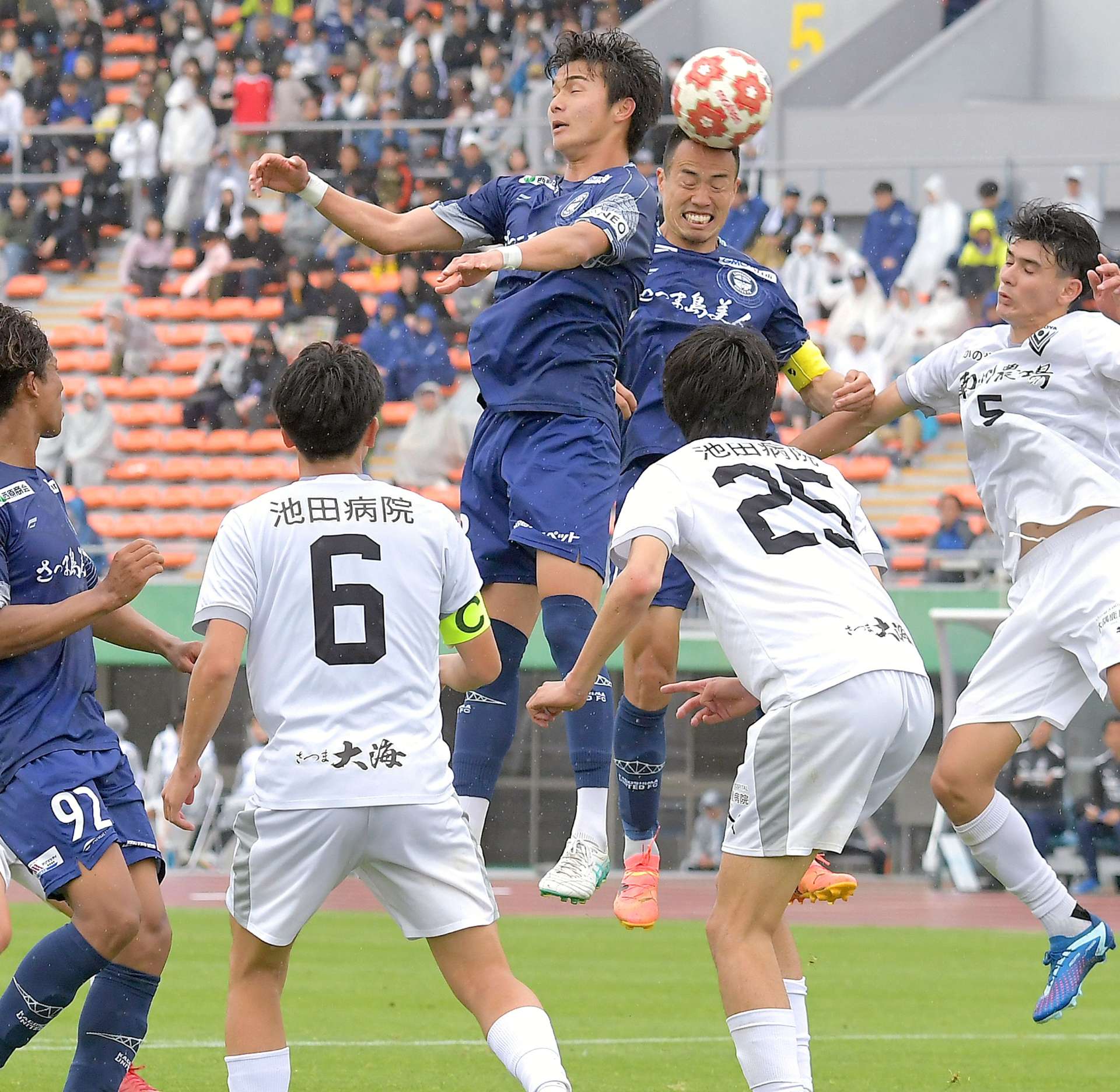 県サッカー選手権決勝の後半、セットプレーからヘディングシュートを狙う鹿児島Ｕの選手たち＝１１日、鹿児島市の白波スタジアム