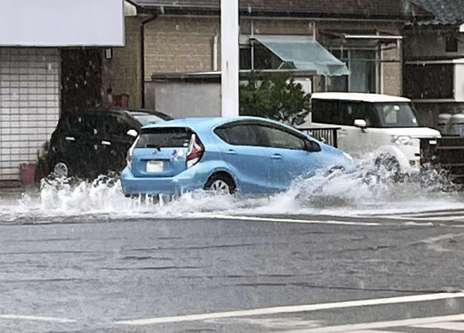 大雨で冠水する県道の「国分中央１丁目」交差点＝２４日、霧島市