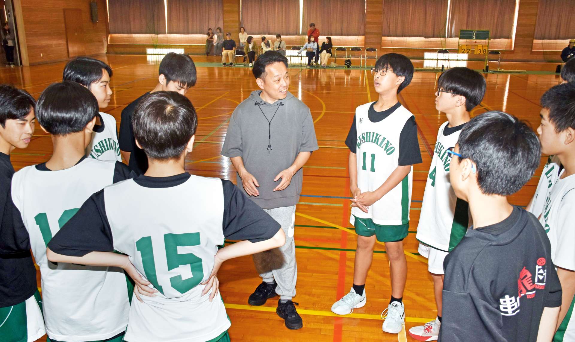 練習試合の合間に、部員たちに声をかける外部指導者の中野和昌さん（中央）＝いちき串木野市の串木野中学校