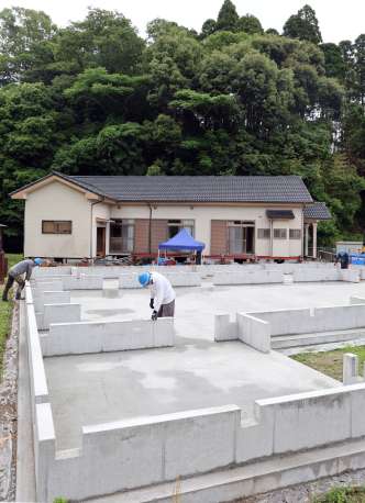 〈別カット〉背後に山が迫った喜入自治会館を曳家で移設するため設置された土台（手前）＝２０日、薩摩川内市平佐町