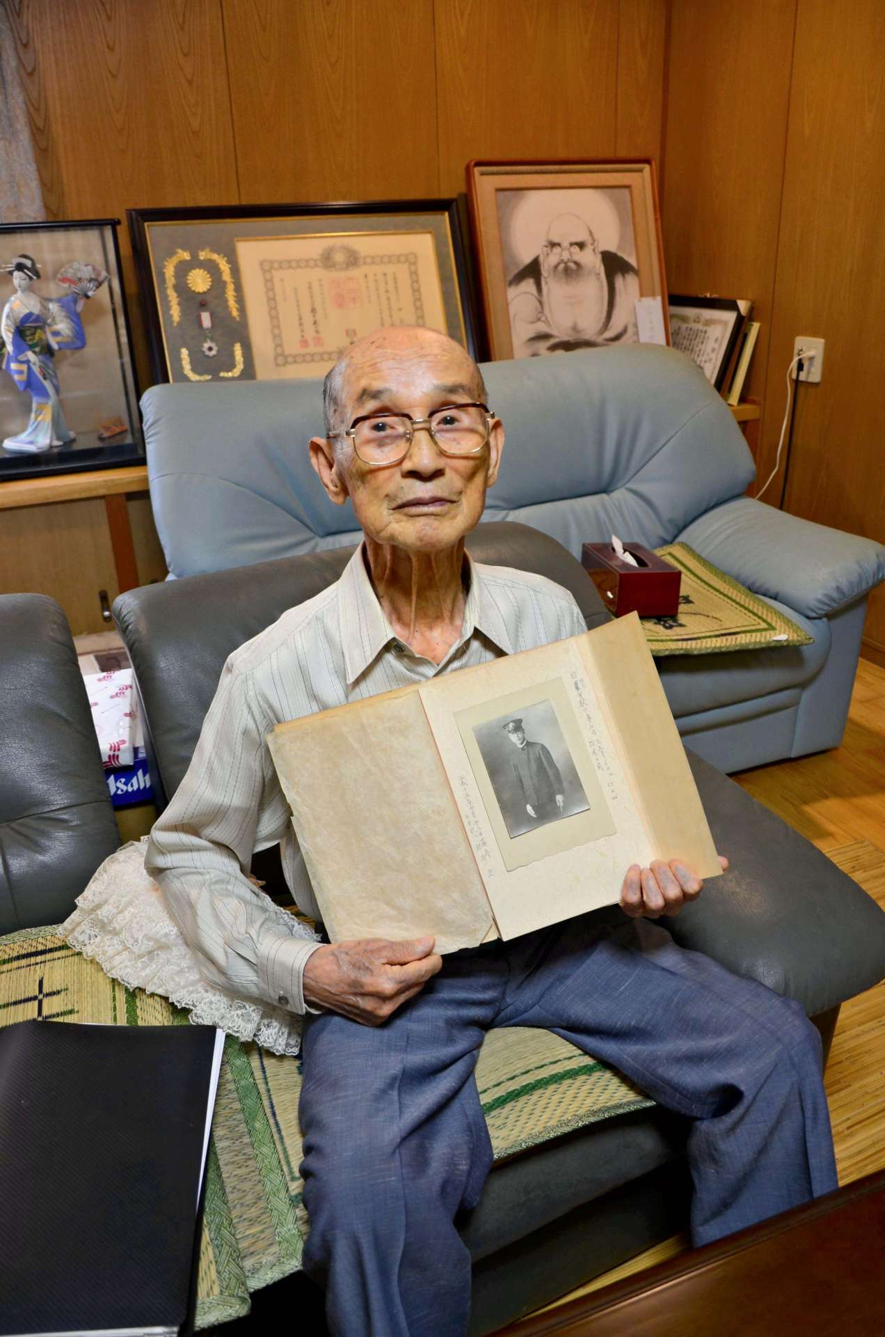 家族から贈られた高松信義軍医長の写真を持つ川畑義照さん＝霧島市牧園町三体堂