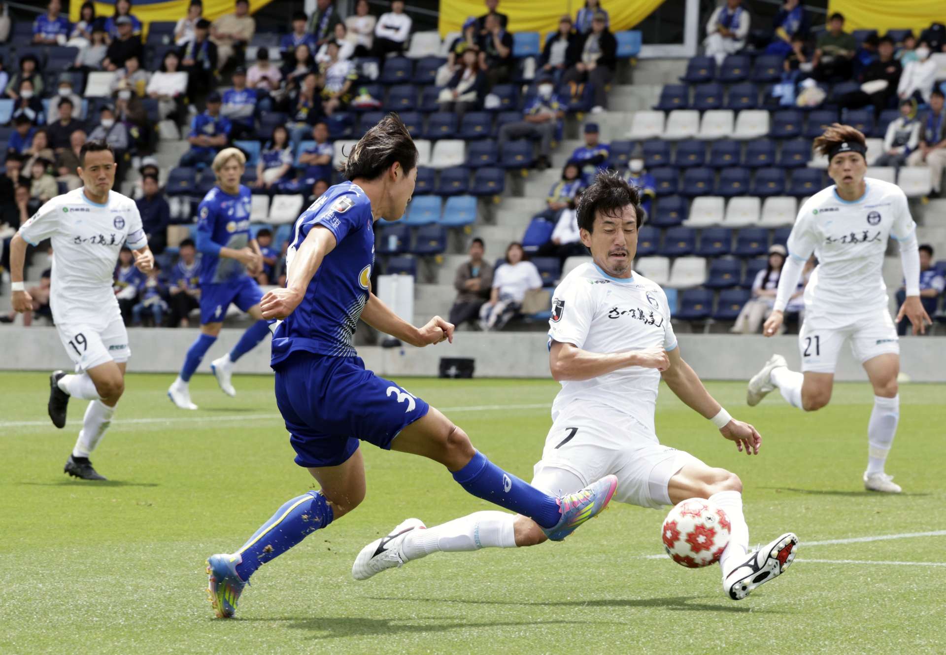 前半、シュートをブロックする鹿児島Ｕの千布＝アシックス里山スタジアム