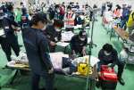 重症者を手当てするＤＭＡＴ関係者＝２５日、さつま町の宮之城運動公園体育館