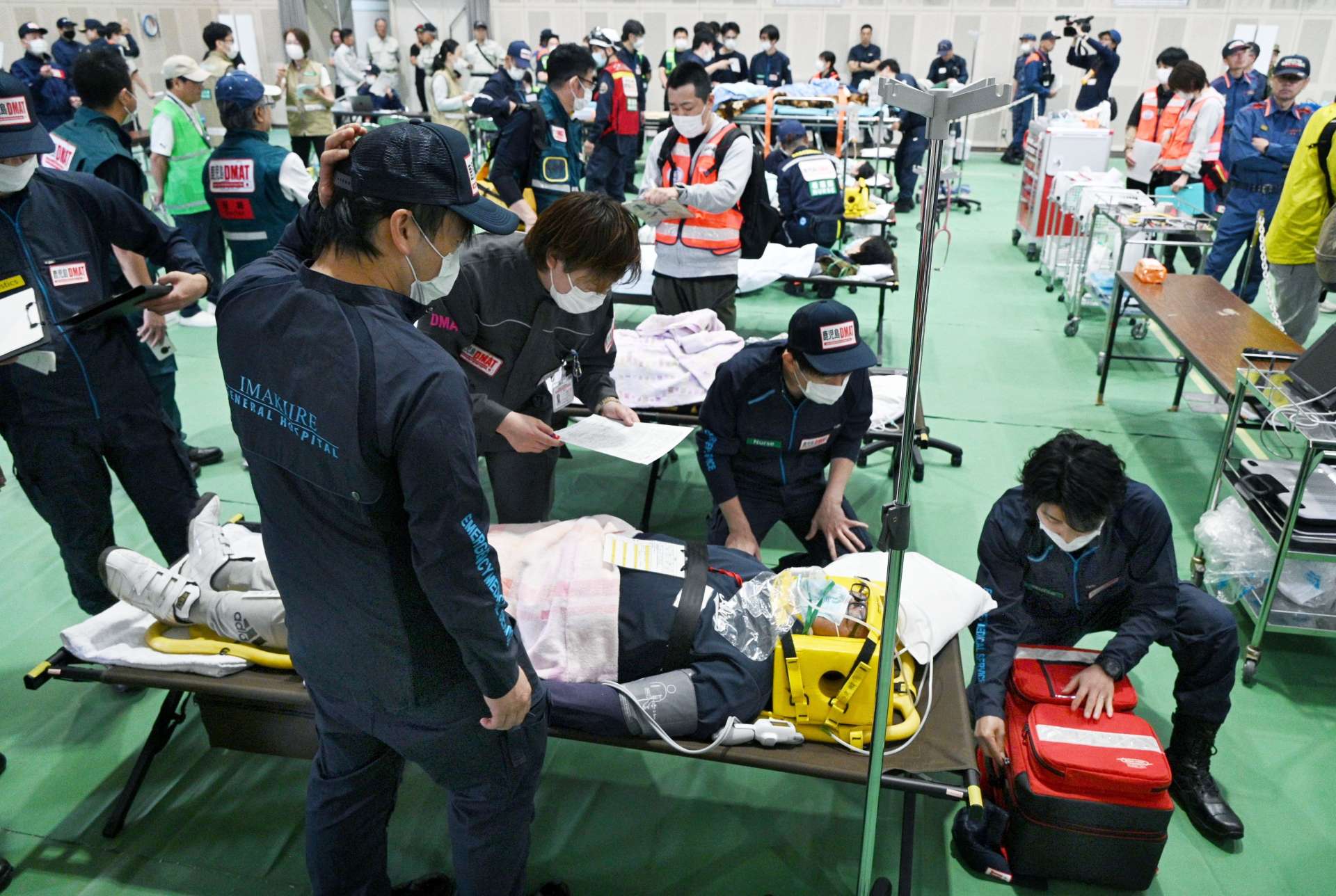 重症者を手当てするＤＭＡＴ関係者＝２５日、さつま町の宮之城運動公園体育館