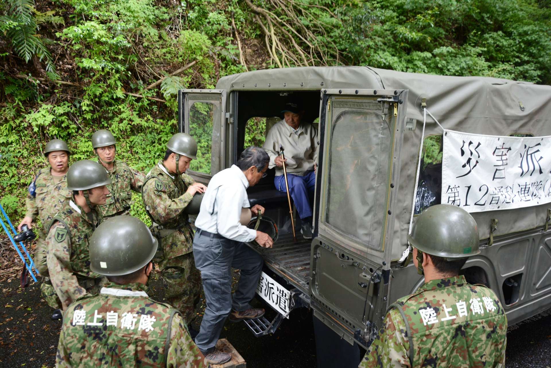 避難するため自衛隊車両に乗り込む薬師集落民＝２５日、さつま町永野