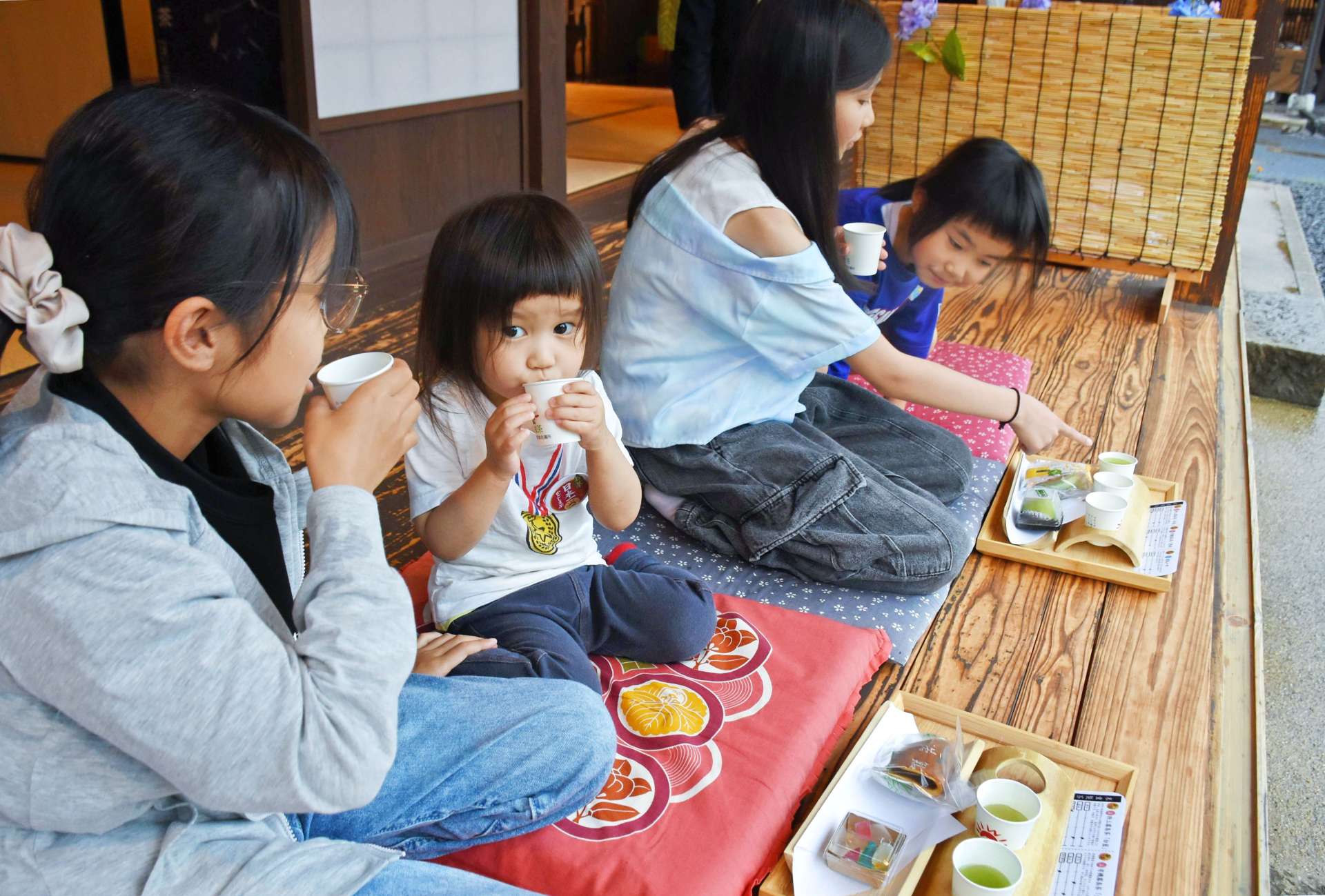 縁側で霧島茶と茶菓子を楽しむ客＝２４日、霧島市隼人の日当山西郷どん村