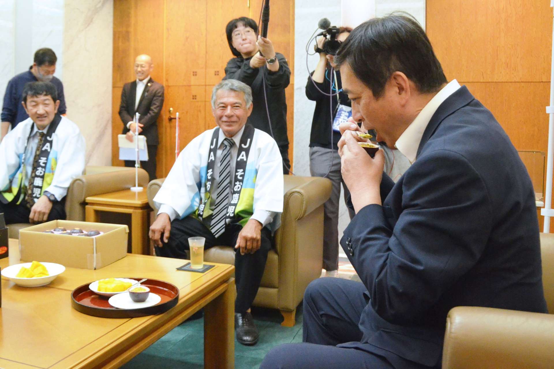パッションフルーツを味わう塩田康一知事（右）＝２６日、県庁