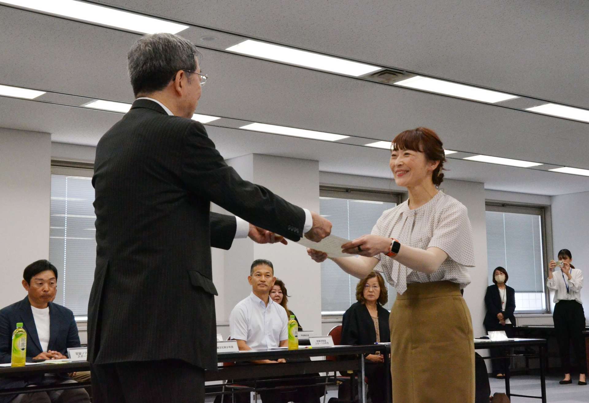 目録を受け取る助成団体の代表者（右）＝２７日、県庁