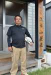 再建した社屋前に立つ久木山栄一さん