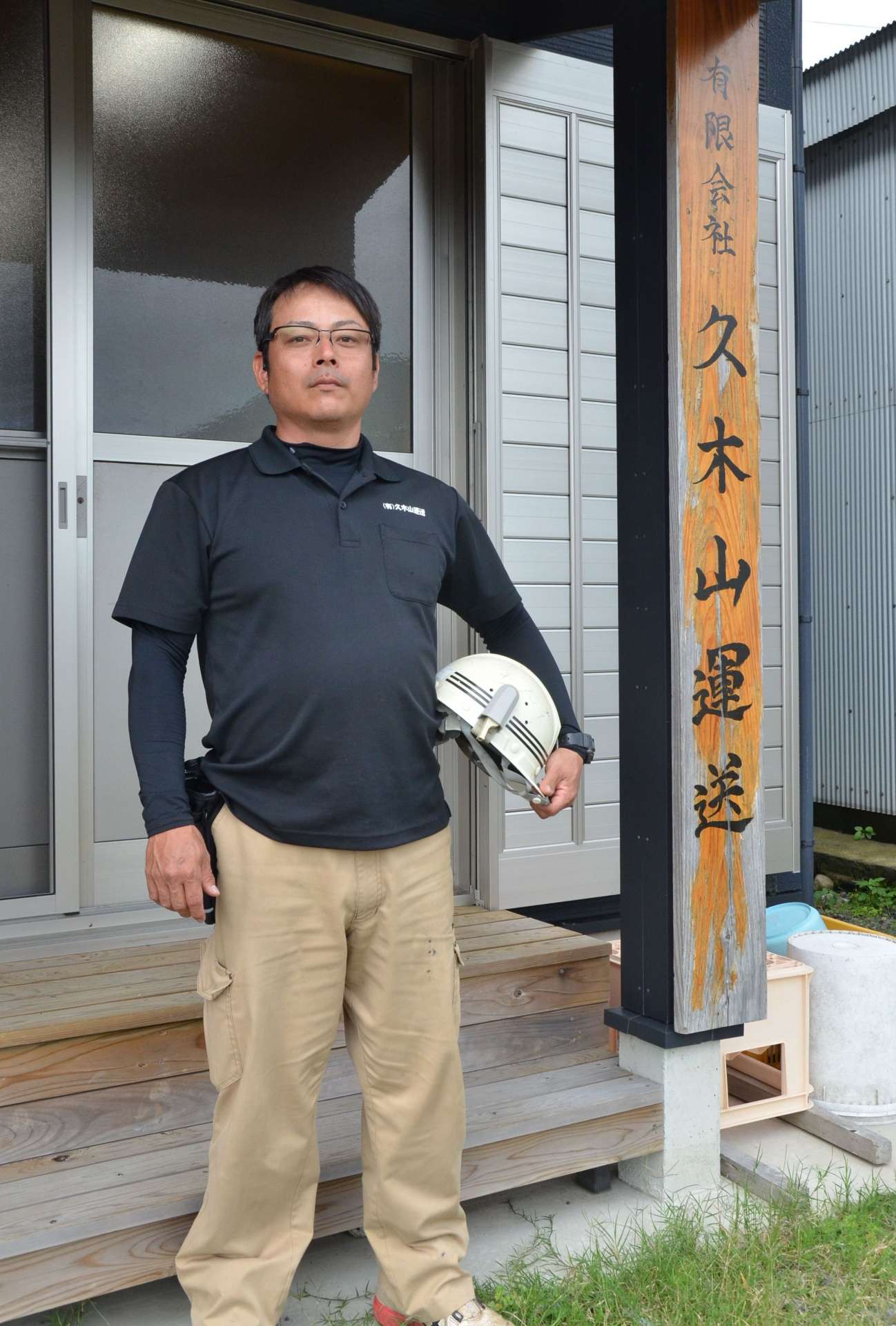 再建した社屋前に立つ久木山栄一さん