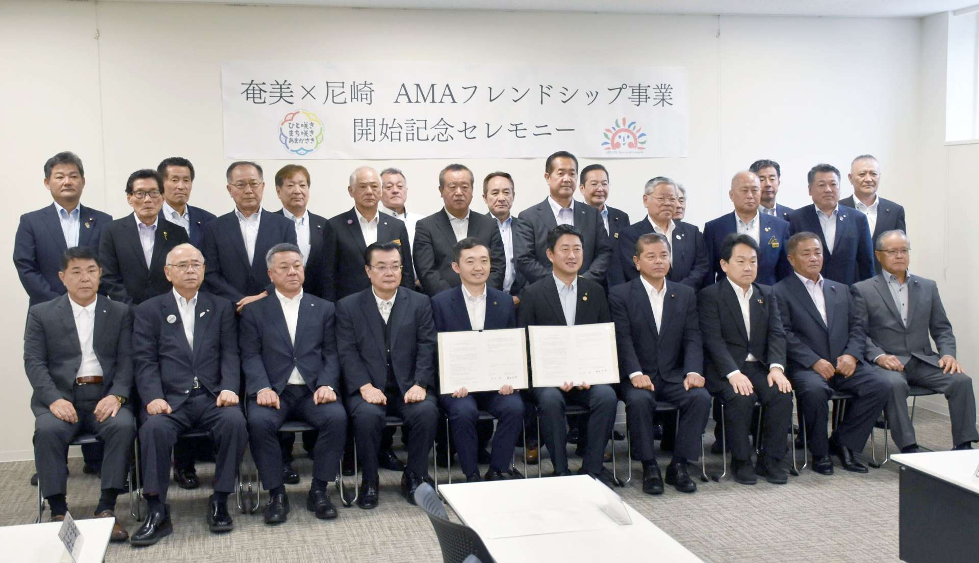 奄美群島の１２市町村の首長らが出席して開かれた締結式＝２６日、奄美市のアマホームＰＬＡＺＡ