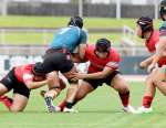２人がかりのタックルで相手を止める加治木工の選手＝白波スタジアム