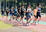 １万５０００メートルのペース走で汗を流す選手＝指宿市営陸上競技場