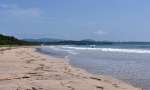 長い砂浜が続く脇本海岸。初夏はサーファーや潮干狩り客が訪れている＝阿久根市