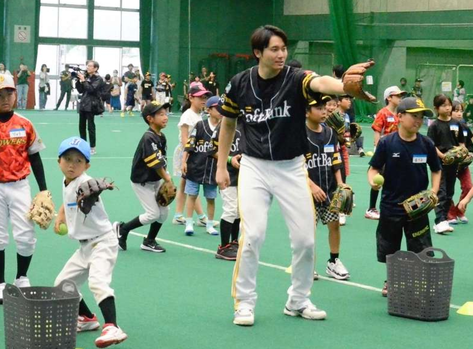 子どもたちに投げるこつを教える元ホークスの選手＝鹿児島市鴨池２丁目の鴨池ドーム