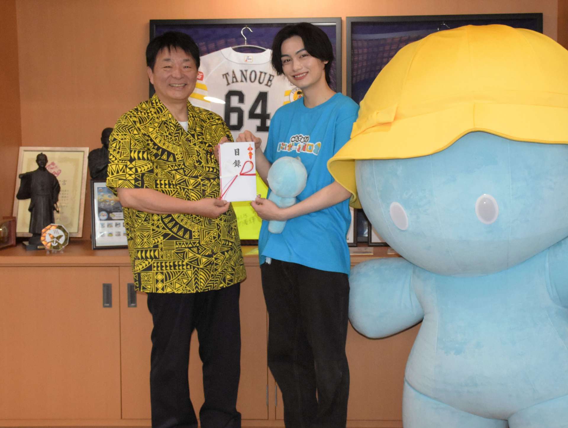 故郷に１０万円を寄付し、笑顔を見せる朝比奈琉良さん（中央）＝５月３０日、指宿市役所