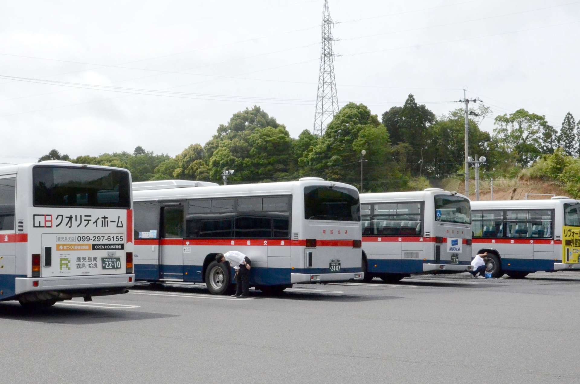休日の南国交通鹿児島営業所で運行前の路線バスを磨く運転手＝５月９日、鹿児島市小野町